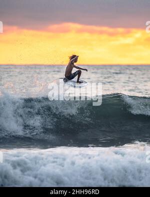 Un surfista jumpin in Costa Rica al tramonto Foto Stock