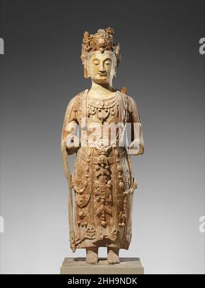 Bodhisattva, probabilmente Avalokiteshvara (Guanyin) ca. 550–560 Cina sculture su larga scala di bodhisattvas indossando gioielli straordinari incarnano innovazioni stilistiche e iconografiche nella scultura cinese della seconda metà del sesto secolo. La stupefacente imbracatura di gioielleria adornante questo bodhisattva è composta da due fili lunghi di grappoli simili a perle e perline sfaccettate. Alcuni elementi, come i pendenti triangolari, hanno precedenti cinesi. Altri, come i cabochons perla, derivano dalle tradizioni dell'Asia Centrale. L'aspetto di tali sculture elaborate figurali, che successivamente b Foto Stock