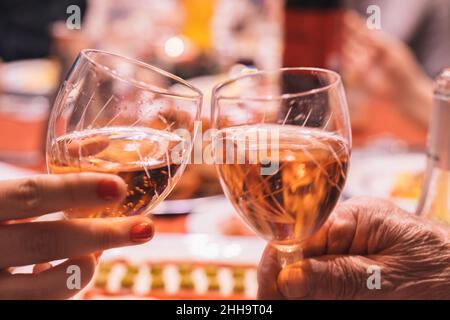 brinda di due bicchieri di vino frizzante di nonno e nipote in occasione di una festa Foto Stock