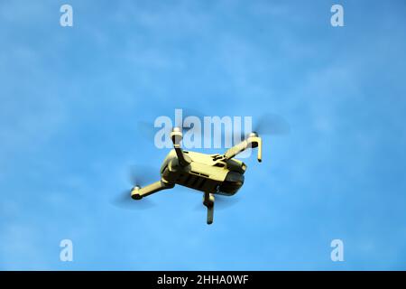 Volo di un piccolo drone contro il cielo blu Foto Stock