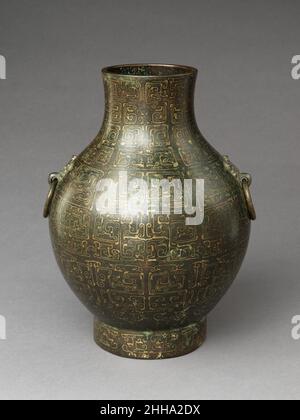 Contenitore di vino (hu) 5th–4th secolo a.C. Cina questo contenitore di vino rituale con squisita decorazione intarsiata illustra una grande innovazione nella tradizione di bronzo della Cina nella dinastia di Zhou tardo orientale quando, ispirato all'arte nomade delle steppe, gli artigiani cinesi hanno creato un sontuoso arredamento superficiale su bronzi altrimenti austeri. Essa incarna anche un cambiamento critico nella funzione dei vasi di bronzo da oggetti rituali a veicoli per la visualizzazione di ricchezza e stato. Contenitore del vino (hu). Cina. 5th–4th secolo a.C. Bronzo intarsiato con rame (oro?). Dinastia Zhou orientale (770–256 a.C.). Metallo Foto Stock