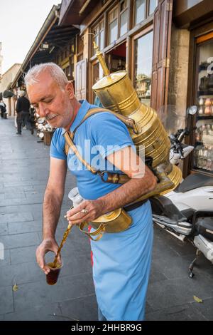 Un venditore di strada versa un bicchiere di bevanda tradizionale fatta con radice di liquirizia, Gaziantep, Turchia Foto Stock