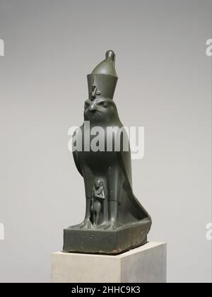 Dio Horus proteggendo re Nectanebo II 360–343 a.C. tardo periodo il faraone Nectanebo II spesso invocava una stretta connessione – anche una fusione – tra se stesso e il Dio falco della regalità, Horus. In realtà, Nectanebo II è stato il fulcro di un culto in cui è stato chiamato 'Nectanebo-the-Falcon', che potrebbe essere ciò che è rappresentato da questa impressionante congiunzione di un potente falco e il monarca. Questa idea sembra essere sostenuta dal fatto che Horus non è chiamato sulla base, solo Nectanebo e il dio Osiride-Mnevis, al cui santuario in Heliopolis la statua può essere stata eretta Foto Stock