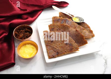 Roti dolci a base di farina di riso, gelate e ghee. gur ki roti. gur ki roti, bhakri gelatinoso, roti meethi gud ki cotto in foglia di banana. Cibo invernale Foto Stock