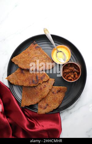 Roti dolci a base di farina di riso, gelate e ghee. gur ki roti. gur ki roti, bhakri gelatinoso, roti meethi gud ki cotto in foglia di banana. Cibo invernale Foto Stock