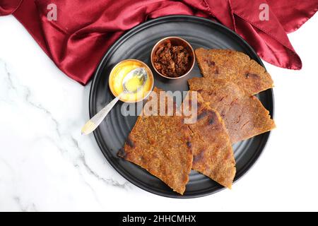 Roti dolci a base di farina di riso, gelate e ghee. gur ki roti. gur ki roti, bhakri gelatinoso, roti meethi gud ki cotto in foglia di banana. Cibo invernale Foto Stock