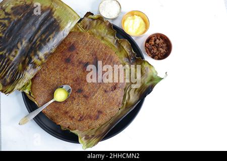 Roti dolci a base di farina di riso, gelate e ghee. gur ki roti. gur ki roti, bhakri gelatinoso, roti meethi gud ki cotto in foglia di banana. Cibo invernale Foto Stock