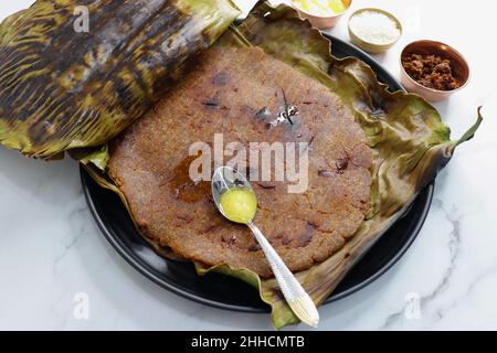 Roti dolci a base di farina di riso, gelate e ghee. gur ki roti. gur ki roti, bhakri gelatinoso, roti meethi gud ki cotto in foglia di banana. Cibo invernale Foto Stock