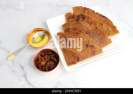 Roti dolci a base di farina di riso, gelate e ghee. gur ki roti. gur ki roti, bhakri gelatinoso, roti meethi gud ki cotto in foglia di banana. Cibo invernale Foto Stock