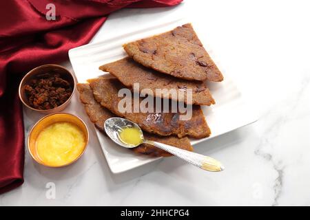 Roti dolci a base di farina di riso, gelate e ghee. gur ki roti. gur ki roti, bhakri gelatinoso, roti meethi gud ki cotto in foglia di banana. Cibo invernale Foto Stock