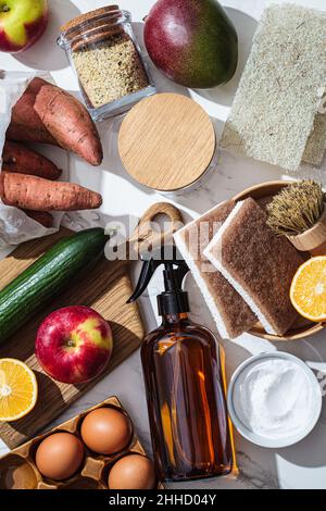 Cucina zero rifiuti concetto. Vita domestica senza plastica. Commercializzare verdure e frutta in sacchi di cotone, spazzole ecologiche e spugne, spray e soda per washi Foto Stock