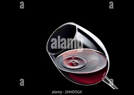 goccia di vino rosso che cade in vetro e creato spruzzi Foto Stock