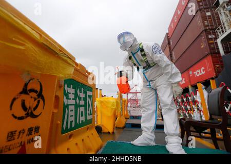 NANJING, CINA - 24 GENNAIO 2022 - gli ufficiali di polizia in servizio disinfettare l'area per la prevenzione epidemica presso il punto di controllo di entrata e di uscita di Nanj Foto Stock