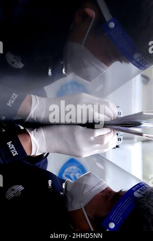 NANJING, CINA - 24 GENNAIO 2022 - gli ufficiali di polizia in servizio presso il checkpoint di frontiera di uscita e di entrata identificano i documenti di ingresso sospetti di Nanjing Por Foto Stock