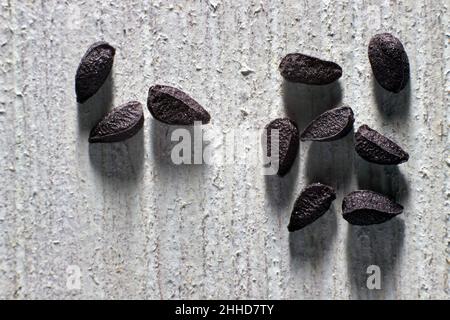 Semi di cumino nero primo piano su un tavolo di legno blu Foto Stock