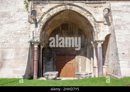 Antico ingresso ad arco con colonne in una spessa fortezza medievale. Foto Stock