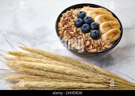 Farina di grano intero con semi di lino con mirtilli e banana Foto Stock