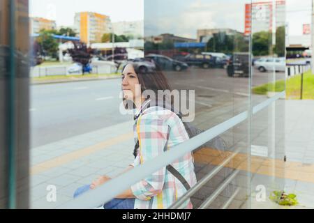 Una giovane donna con sua figlia è in attesa di un autobus pubblico alla stazione degli autobus Foto Stock