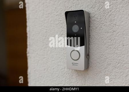 campanello sul muro della casa con una telecamera di sorveglianza Foto Stock