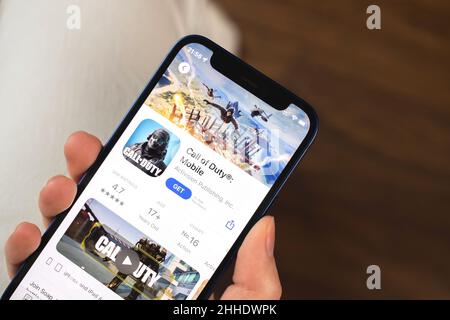 Kharkov, Ucraina - 19 gennaio 2022: App di gioco Call of Duty Mobile. Ragazza che tiene il telefono cellulare con gioco e vuole giocare. Il concetto popolare di giochi per dispositivi mobili Foto Stock