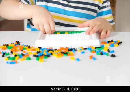 Mani e mosaici del bambino. Giocattoli per lo sviluppo di belle abilità motorie e pensiero creativo. Foto Stock