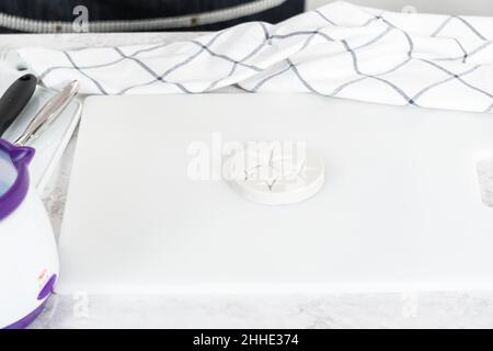 Riempire lo stampo di cioccolato al silicone con cioccolato fuso per  preparare mini cioccolatini rosa Foto stock - Alamy