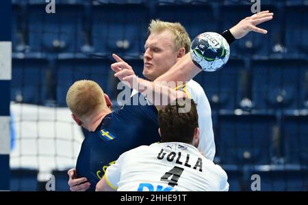 Bratislava, Slovacchia. 23rd Jan 2022. Pallamano: Campionato europeo, Germania - Svezia, turno principale, Gruppo 2, giornata 3. Patrick Wiencek (dall'alto verso il basso) in azione con Jim Gottfridsson in Svezia e Johannes Golla in Germania. Il 24 gennaio 2022, il DHB aveva annunciato altri due casi positivi di Corona, tra cui Wiencek. Credit: Marijan Murat/dpa/Alamy Live News Foto Stock