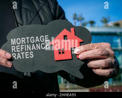 L'uomo mostra l'iscrizione tassi di rifinanziamento ipotecari e casa. Foto Stock