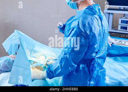 Il team medico di chirurghi in ospedale facendo minimamente invasivo di interventi chirurgici. La chirurgia sala operatoria con apparecchiature di elettrocauterizzazione per cardiovas Foto Stock