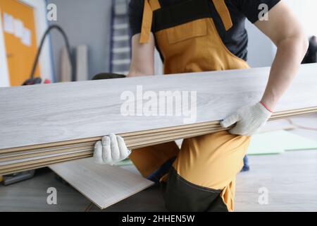 Un riparatore in uniforme tiene in primo piano i pannelli laminati Foto Stock