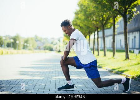 Atletico afroamericano che fa allenamenti mattutini, stretching e fitness Foto Stock