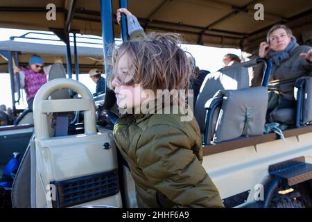 Ragazzo giovane in veicolo safari, Delta Okavango, Botswana Foto Stock