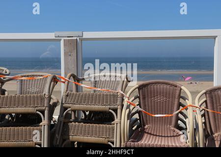 Sedie impilate su ristorante spiaggia chiuso il giorno estivo di sole a Zandvoort, Paesi Bassi Foto Stock