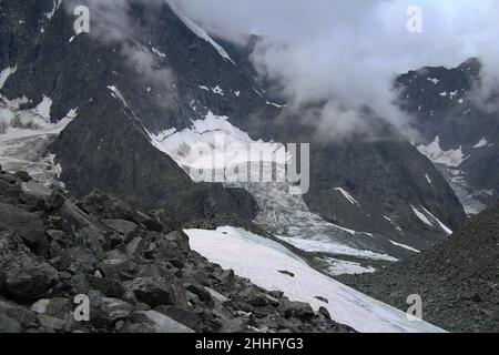 Ghiacciaio in una montagna rocciosa ad Altai vicino al monte Belukha con nuvole e pietre Foto Stock