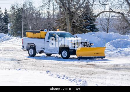 Autocarro per aratro di proprietà della città in un parcheggio dopo aver terminato il lavoro di rimozione della neve. Foto Stock