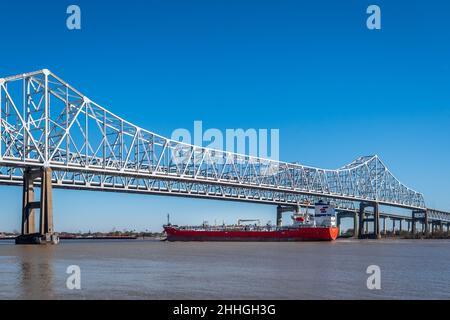 Porto di New Orleans sul fiume Mississippi con una barca, nave, chiatta, passando sotto il Mississippi River Bridge, Louisiana, USA. Foto Stock