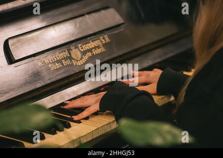 Belle mani con lunghe dita di una ragazza con unghie laccate nere che suonano un vecchio pianoforte Weissbrod Eisenberg Foto Stock