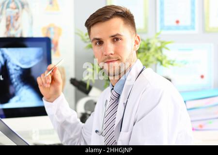 Il medico esamina la radiografia del primo piano della colonna cervicale Foto Stock