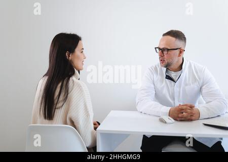 Giovane donna su appuntamento del medico. Medico che dà consigli a paziente femminile Foto Stock