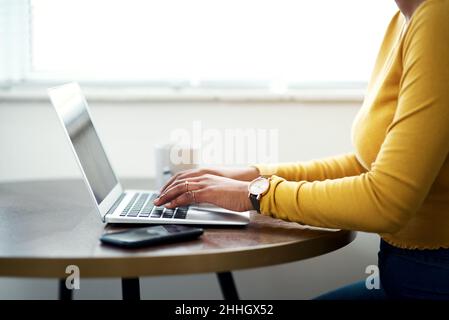 Blogging da casa è il mio favorito. Scatto corto di una donna irriconoscibile seduta da sola e utilizzando il suo laptop mentre a casa. Foto Stock