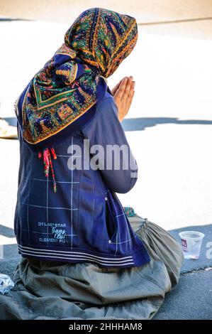 PARIGI - AGOSTO 15: Donna che chiede l'elemosina sul ponte vicino alla Cattedrale di Notre Dame il 15 agosto 2013 a Parigi, Francia. I mendicanti lavorano nel più popolare shopping Foto Stock