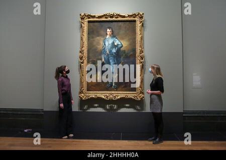 Londra, Regno Unito. 24th Jan 2022. I membri del personale si presentano di fronte al dipinto "Blue Boy" di Thomas Gainsborough durante l'anteprima della stampa presso la National Gallery. I dipinti di Thomas Gainsborough saranno esposti presso la National Gallery dal 25 gennaio al 15 maggio 2022. Credit: SOPA Images Limited/Alamy Live News Foto Stock