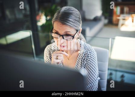 Tecnologia avanzata per una maggiore produttività. Shot di una donna d'affari matura che utilizza un computer in un ufficio moderno. Foto Stock