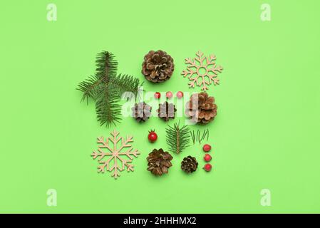 Composizione con rami di abete, coni di pino e fiocchi di neve su sfondo verde Foto Stock