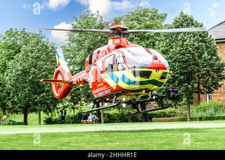 Thames Valley Air Ambulance equipaggio chiamato a uno sviluppo di alloggi per stabilizzare e trasportare un paziente in ospedale. Foto Stock