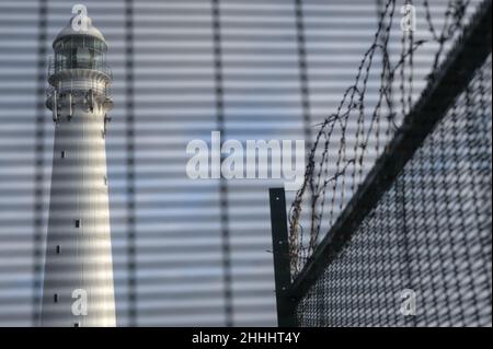 Una recinzione di sicurezza difende il faro di Kommetjie sulla costa atlantica della Penisola del Capo in Sudafrica vicino alla città portuale di Città del Capo Foto Stock