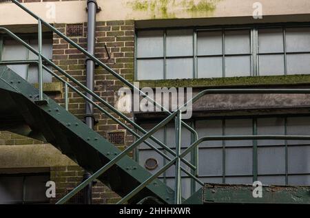 il fuoco di metallo arrugginito sfugge sul lato di un vecchio edificio di mattoni Foto Stock