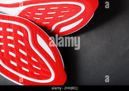 Scarpe da running con suole rosse su sfondo nero. Primo piano, vista dall'alto Foto Stock