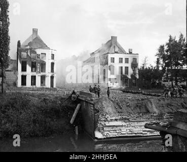 La difesa di Lierre questa foto è stata scattata subito dopo la caduta della città belga di Lierre, che si trova a 15 miglia da Anversa e mostra Royal Marines che hanno fatto saltare il ponte sul fiume Nethe stanno abbassando tutto ciò che potrebbe permettersi la copertura nemica. Dall'altra parte del ponte Marines attende l'attacco. Le case che si affacciano sul ponte e sul fiume sono state distrutte mentre i tedeschi annientavano attraverso le finestre. Il piccolo gruppo di marines intrappolati sulla riva lontana riuscì a fuggire attraversando il fiume in piccole barche. Circa Ottobre 2nd 1914 *** Local Caption *** Publish Foto Stock