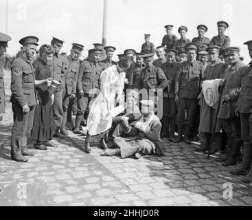 Banchina di St Nazaire 23rd 1914 settembre. Una donna francese ha visto qui dare una bevanda d'acqua ad un prigioniero tedesco mentre i soldati britannici e tedeschi feriti guardano sopra. I feriti si erano riuniti al porto per attendere l'arrivo di una nave ospedaliera che li riporterà tutti nel Regno Unito Foto Stock